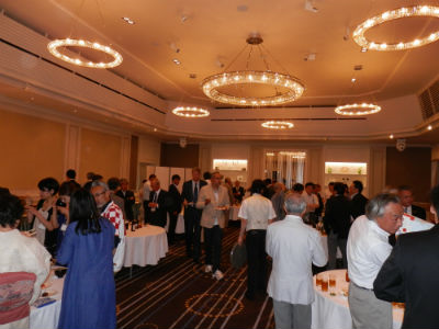 大勢のクロアチア人と日本人が宴会場で交流している様子