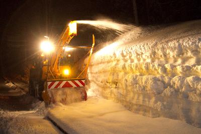 歩道の雪を歩行者専用除雪車が掻き出している様子の写真