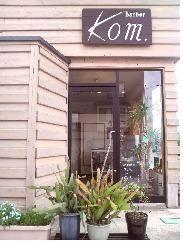 植物が店先に置かれたKom.(コム)店舗外観の写真