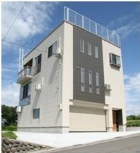 青空の下、撮影された耐雪住宅施工例の建物の写真