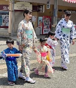 浴衣を着た女性と子どもたちが街を歩いている様子