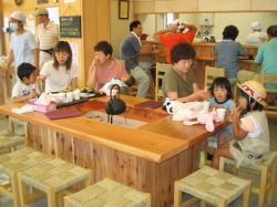 カウンターと椅子が置かれた店内にたくさんの人達がいる写真