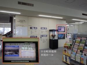 十日町市役所1階市民ホールにある表示モニターと、拡大されたモニターの写真