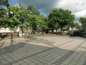 西側より撮影されたきもの広場の景観の写真。あずまや周辺やその奥に多くの樹木が茂っているのが確認できる