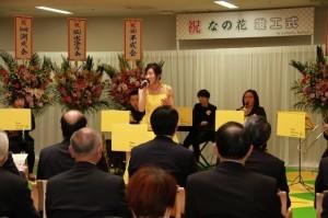 竣工式のオープニングセレモニーにて歌と音楽演奏を披露する苗場福祉会職員たちの写真