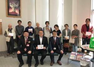 国宝シリーズ第1集考古資料特殊切手シート発行に臨んで記念撮影に応じる、市長と郵便局職員および地区の皆さんの写真