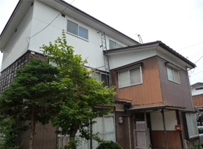 白と茶色の木造2階建て一軒家の写真