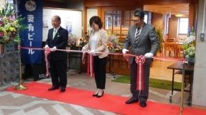 グランドオープンセレモニーにてテープカットを行う白倉代表と尾身県議会議員および市長の写真