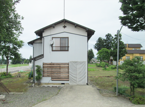 整備された芝生と木が周りにある立地の白い2階建て一軒家の写真