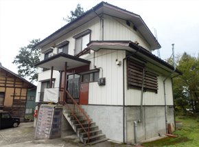コンクリートの高床式白い2階建て一軒家の写真