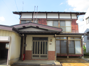 赤茶と白の木造2階建て一軒家の写真