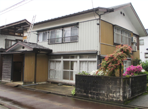 白と薄茶色の2階建て一軒家の写真