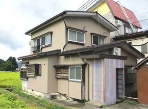 整備された草原のあるベージュの2階建て一軒家の写真