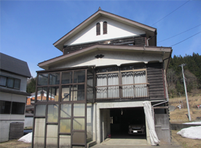 2階までの階段がガラスの壁に覆われた3階建て一軒家の写真
