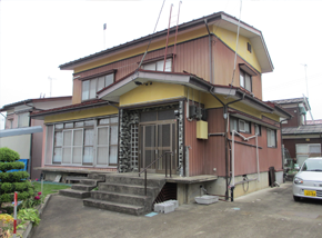 玄関までに少し階段のある茶色い2階建て一軒家の写真