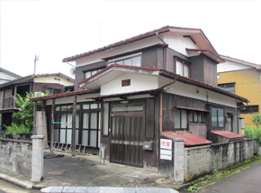赤い屋根の白い2階建て一軒家の写真