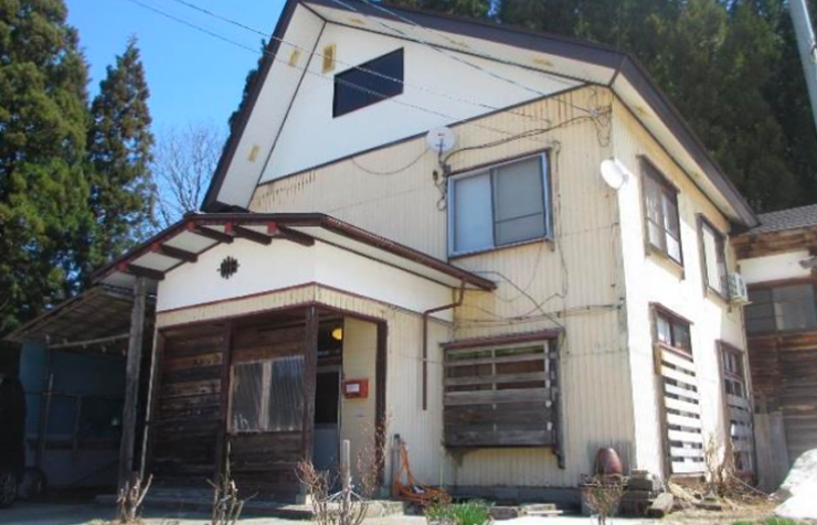 屋根裏部屋のある白い3階建て一軒家の写真