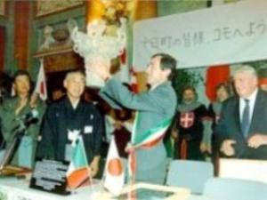 国宝のレプリカを両手で持ち笑顔で掲げる男性とその隣で笑顔で写る和服姿の男性の写真