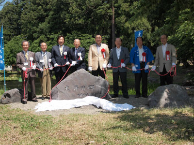 石碑の後ろに立って記念撮影をする関口市長と関係者たち。