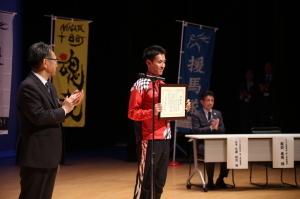 凱旋報告会にて感謝状を受領する服部勇馬選手の写真