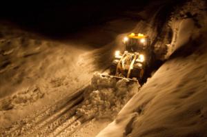 除雪ドーザーが道路の雪を掻き出している様子の写真