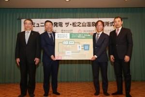 説明パネルとともに撮影されたコミュニティ発電 ザ・松之山温泉開所式の写真
