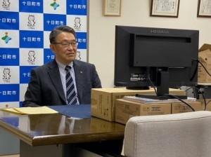 十日町市の背景を使って行われている、世田谷CATVでの市長のリモート収録の様子の写真