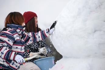 雪像制作にチェレンジしている女性2人の様子の写真