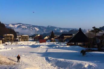 寒くて澄み切った空に映える山々と雪原の様子の写真