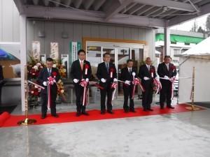 竣工式にて来賓と共にテープカットを行う市長の写真