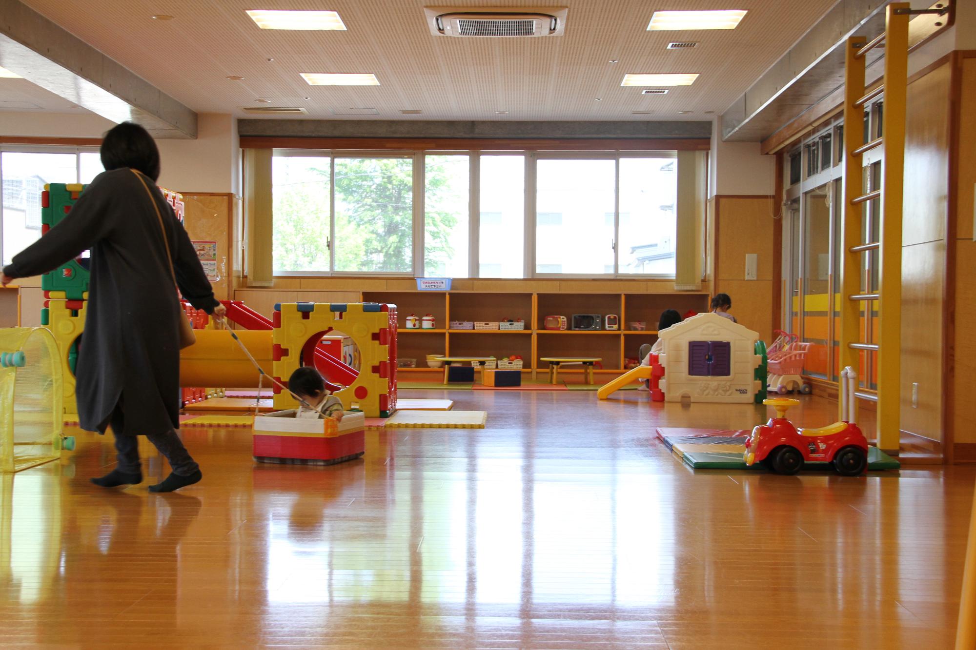 子育て支援センターで遊んでいる赤ちゃんと母親