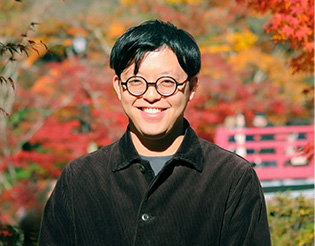 紅葉をバックに笑っている男性