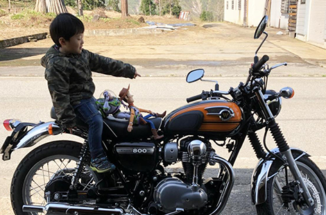 大型バイクに跨る男の子と2体の人形