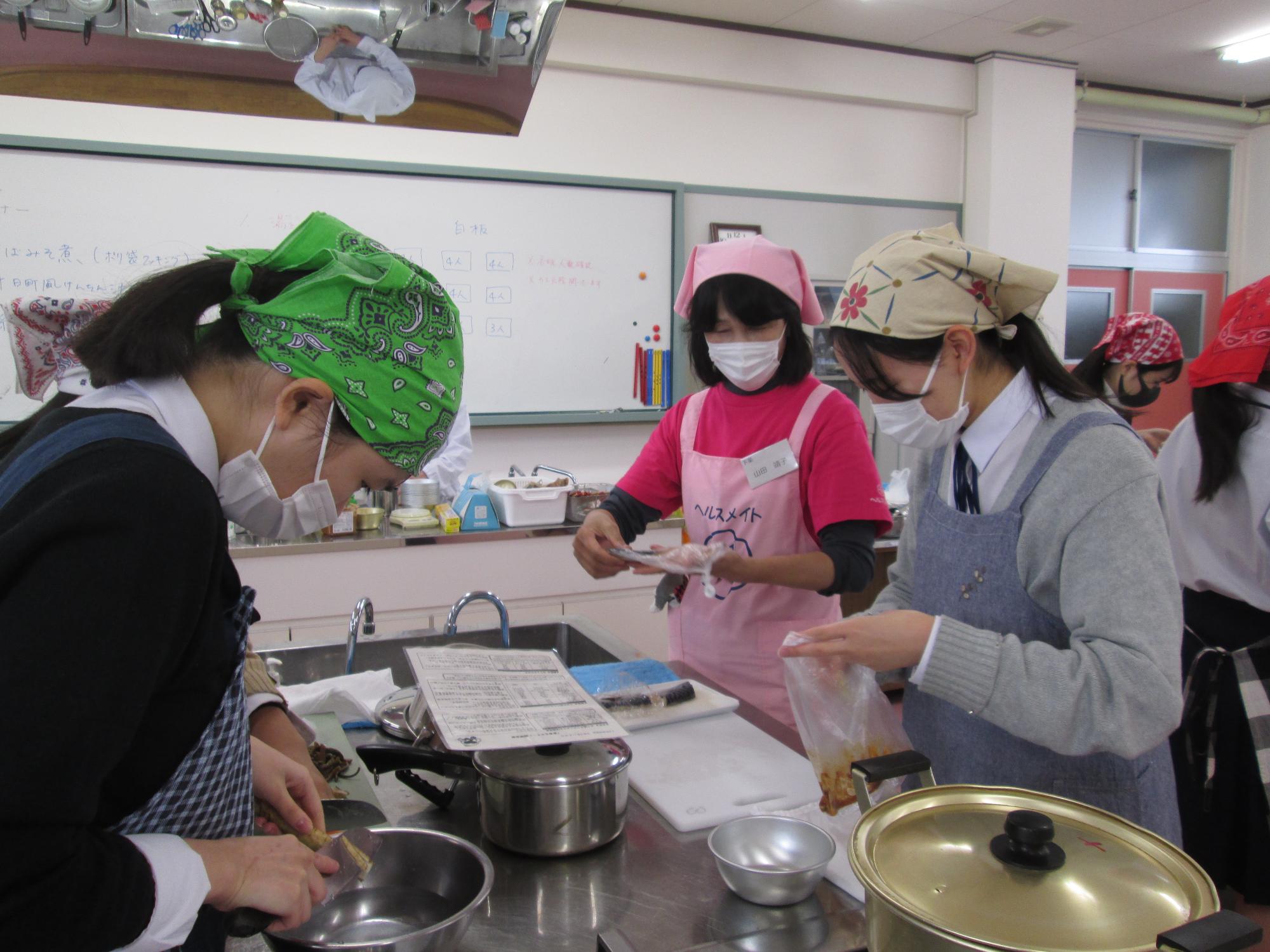 調理室で食生活改善推進員と高校生が調理実習をしている写真