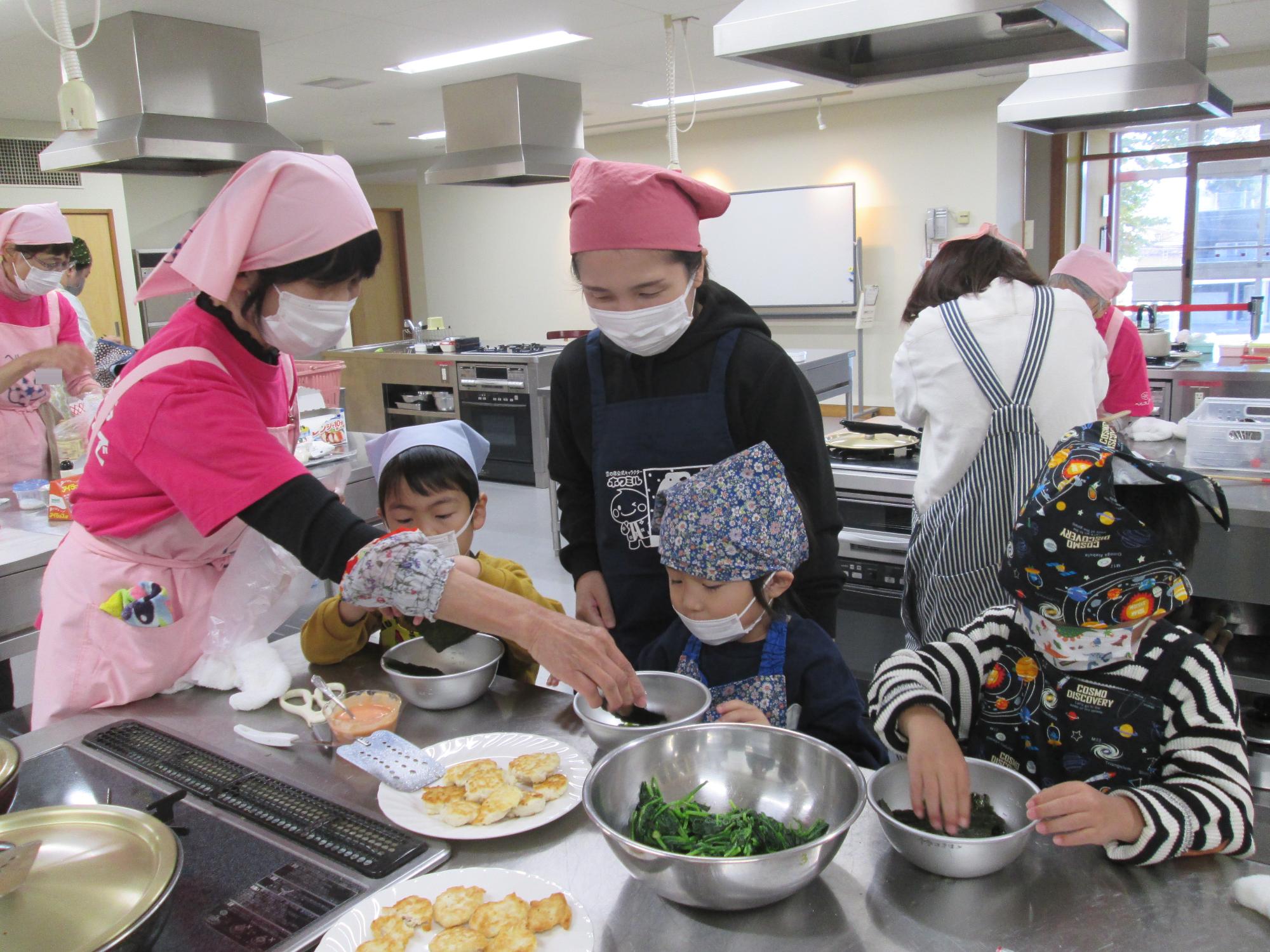 園児を対象とした食育教室で、調理を行う親子とヘルスメイト