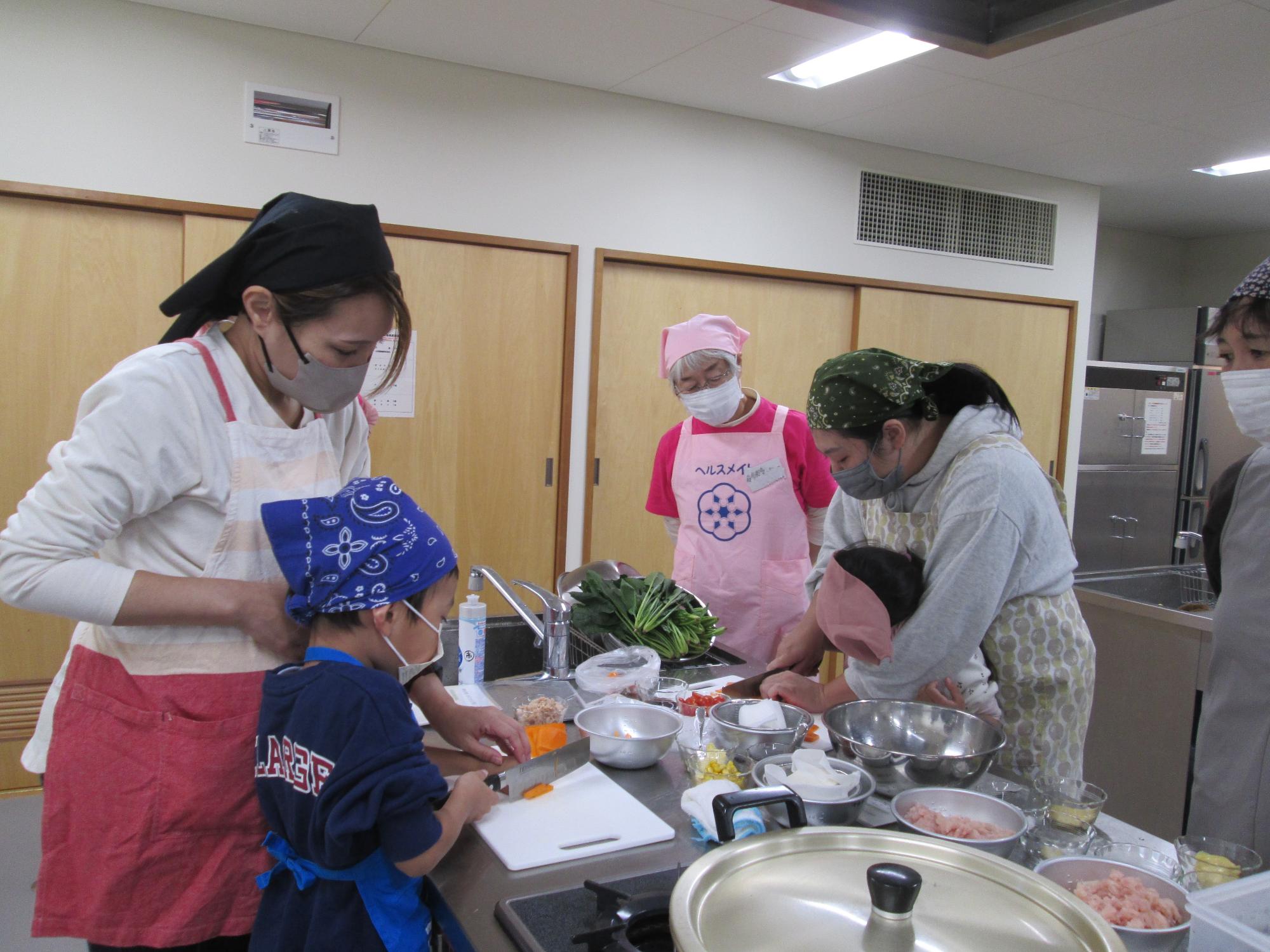 園児を対象とした食育教室で、調理を行う親子とヘルスメイト