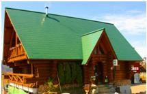 緑色の屋根が特徴的なカネタケ建設ログハウス外観の写真
