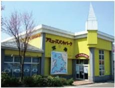黄色い外壁が特徴的なハピピランド 十日町店の外観の写真