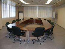 楕円形の机の周囲に椅子が用意されている特別会議室の写真