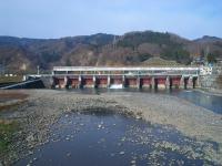 川に向かうように施設が建っている、宮中取水ダムの遠景の写真