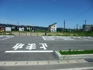 にしさん公園の駐車場の写真。駐車場には12台分の駐車スペースがあり、うち1箇所に障害者等用駐車スペースが設けられているのが確認できる