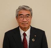眼鏡をかけ、スーツを着て微笑んでいる鈴木一郎議員の写真