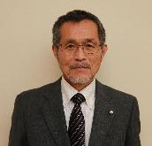 眼鏡をかけ、スーツを着て微笑んでいる鈴木和雄議員の写真