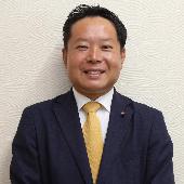 スーツを着て微笑んでいる星名大輔議員の写真