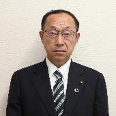 スーツを着て立っている野沢浩平議員の写真