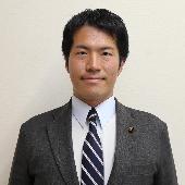 スーツを着て微笑んでいる山家悠平議員の写真