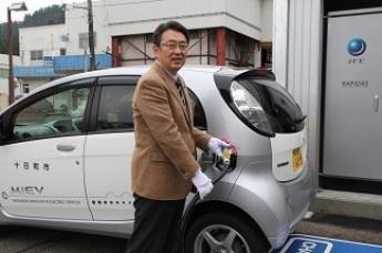 通電式において市長が電気自動車への充電を行っている写真