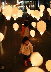 復興記念イベントで子どもたちが灯りの付いた風船を眺めている写真