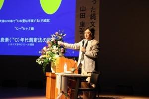 壇上にて講演を行う山田教授の写真