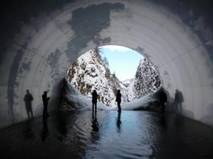 視察において水がたまった清津峡渓谷トンネルの内側から雪の積もった出口際に来ている様子の写真